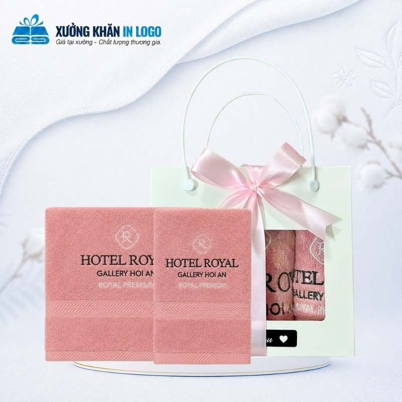 Set 2 khăn cotton màu hồng SKB-09 thêu logo sắc nét đặt cạnh hộp giấy quai xách thắt nơ hồng dịu dàng